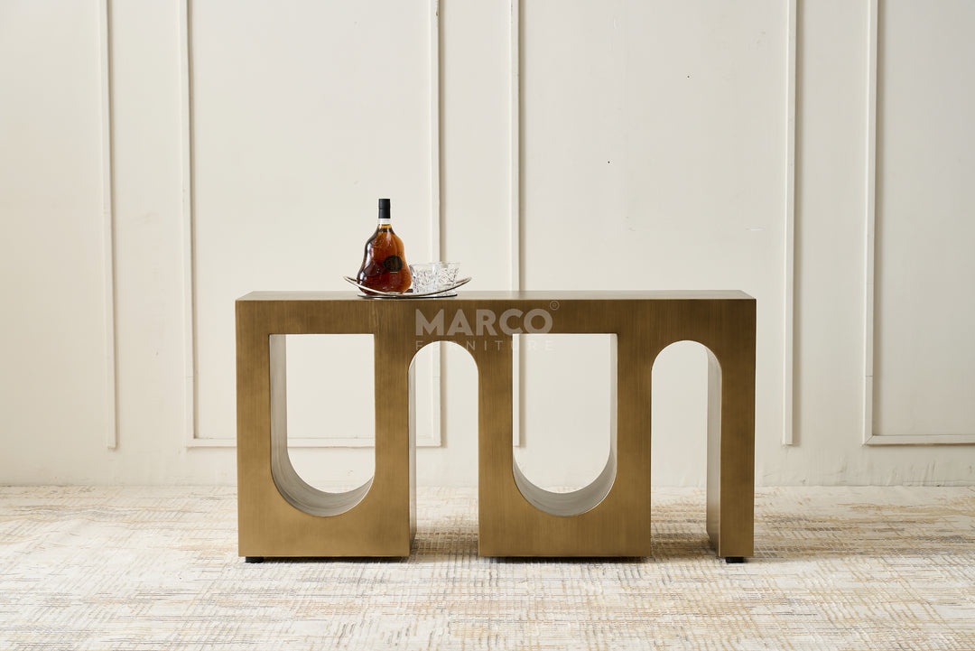 Modern metallic side table with a bottle on a white paneled wall background