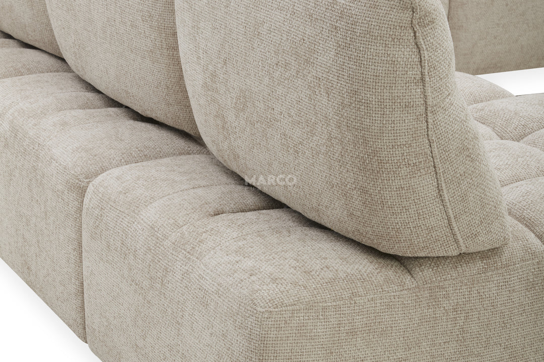 Close-up of a beige textured sofa with 'Marco' branding.