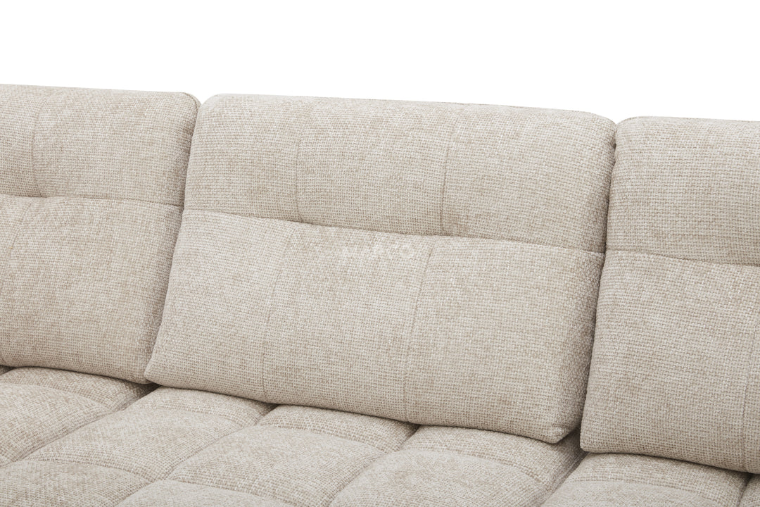 Beige fabric sofa with a quilted pattern on a white background