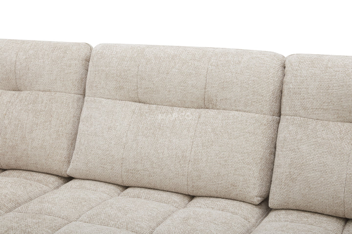 Beige fabric sofa with a quilted pattern on a white background
