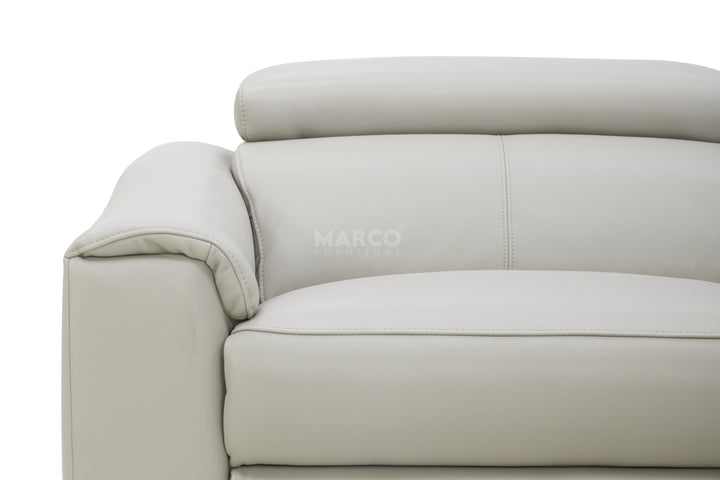 Close-up of a beige sofa with 'MARCO' branding on a white background