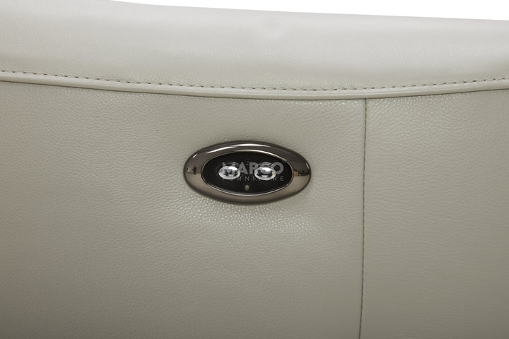 Close-up of a beige leather product with a silver logo on a white background