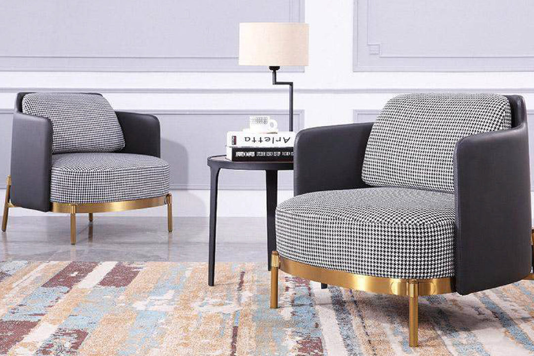 Two modern armchairs with gold legs in a living room setting.