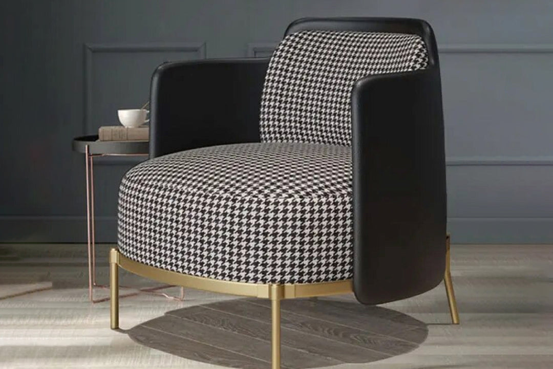 Modern armchair with black and white patterned seat and backrest in a room setting.