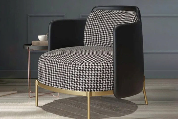 Modern armchair with black and white patterned seat and backrest in a room setting.