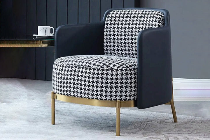 Modern armchair with houndstooth pattern and gold legs in a room setting.
