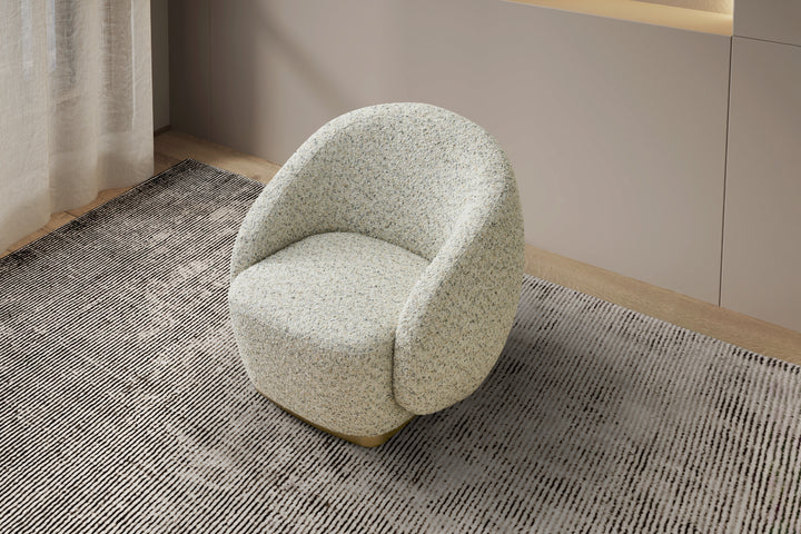 Light green textured armchair on a patterned rug with a neutral wall background