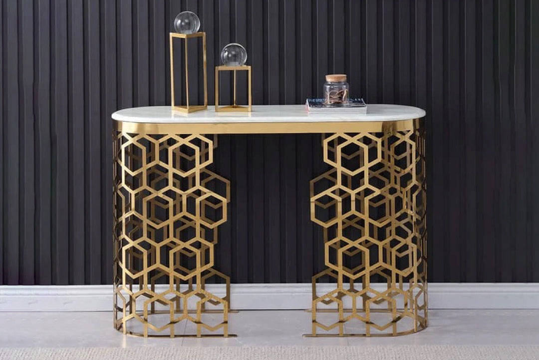 Console table with gold geometric design against a dark curtain background