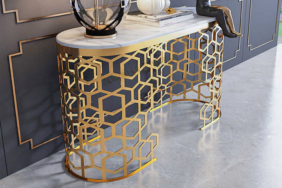 Decorative console table with geometric gold design on a gray floor.