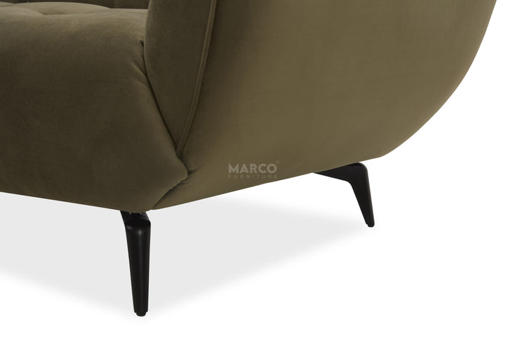 Close-up of a brown armchair with black legs on a white background, featuring the brand 'Marco'.