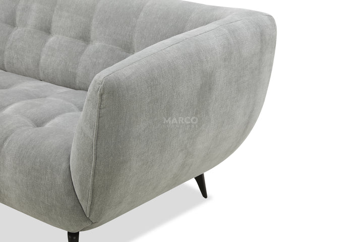 Gray sofa with tufted design on a white background, featuring the brand 'MARCO'.
