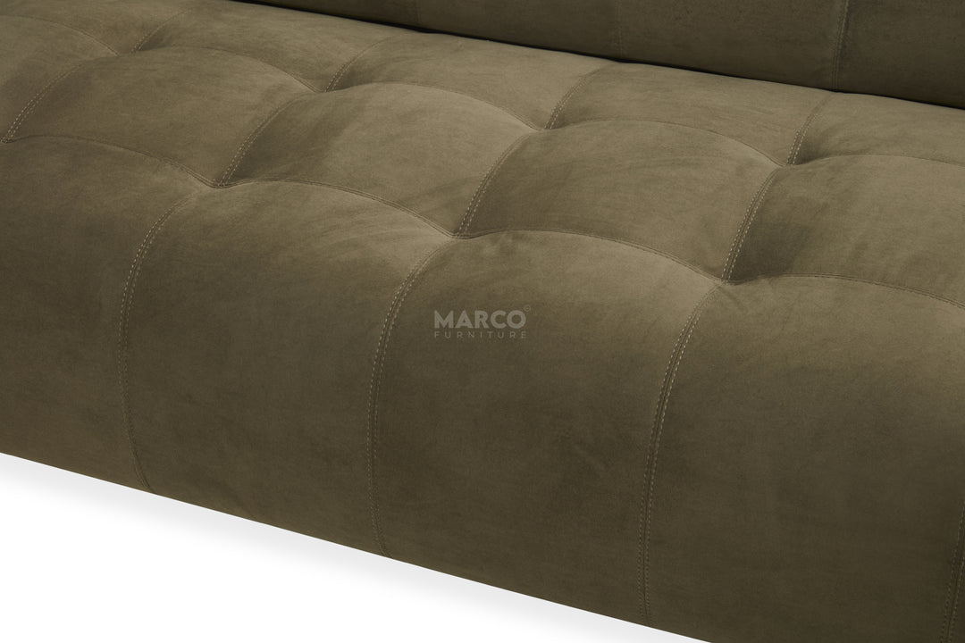 Close-up of a tufted brown sofa with 'Marco' branding.