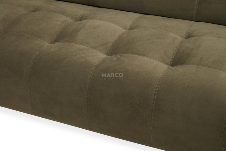 Close-up of a tufted brown sofa with 'Marco' branding.