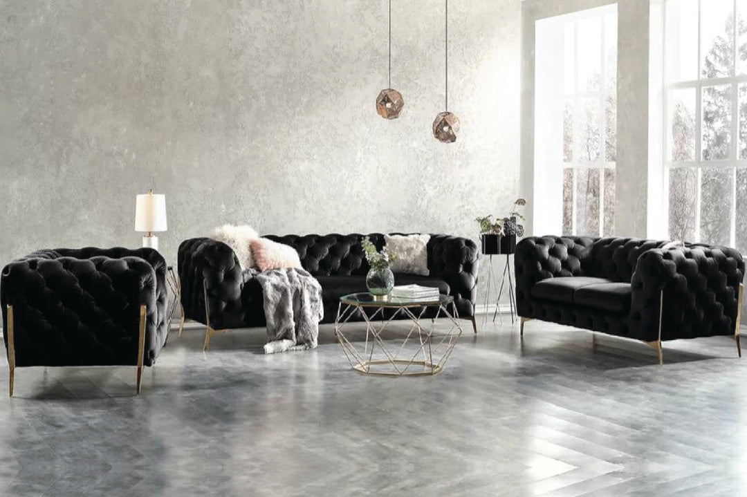 Modern living room with black leather sofas and a geometric coffee table.