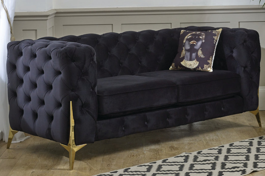 Navy velvet sofa with gold legs in a room setting