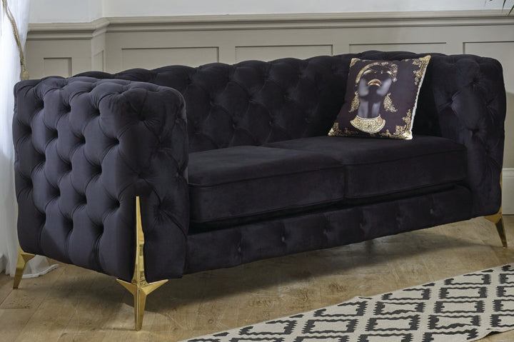 Navy velvet sofa with gold legs in a room setting