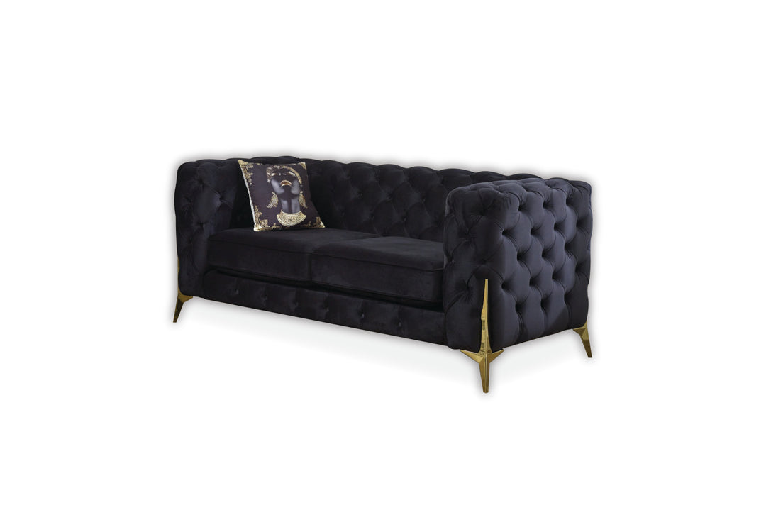 Navy blue tufted sofa with a decorative pillow on a white background