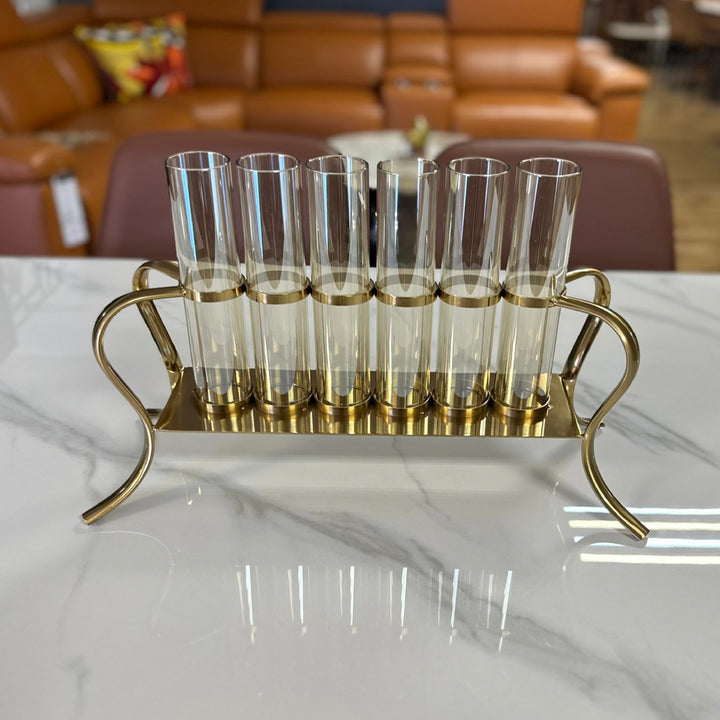 Set of clear glasses on a gold stand with a blurred background