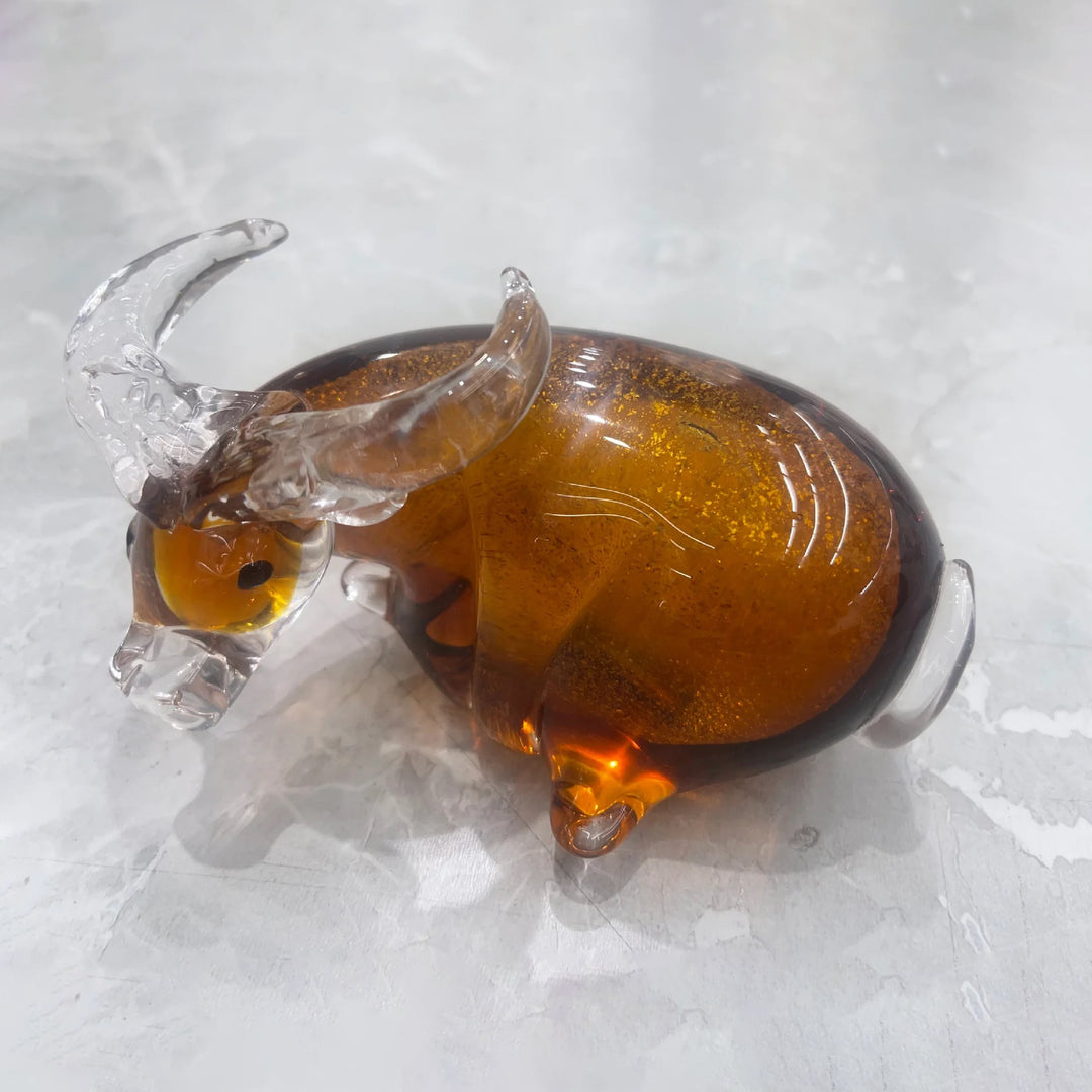 Glass figurine of a bear with a honeycomb in its mouth on a light gray background