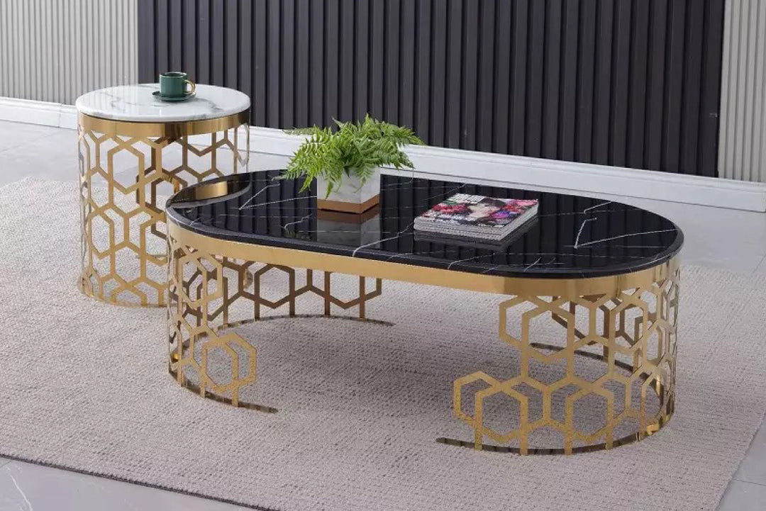 Decorative coffee table with geometric gold frame and black glass top in a room setting.