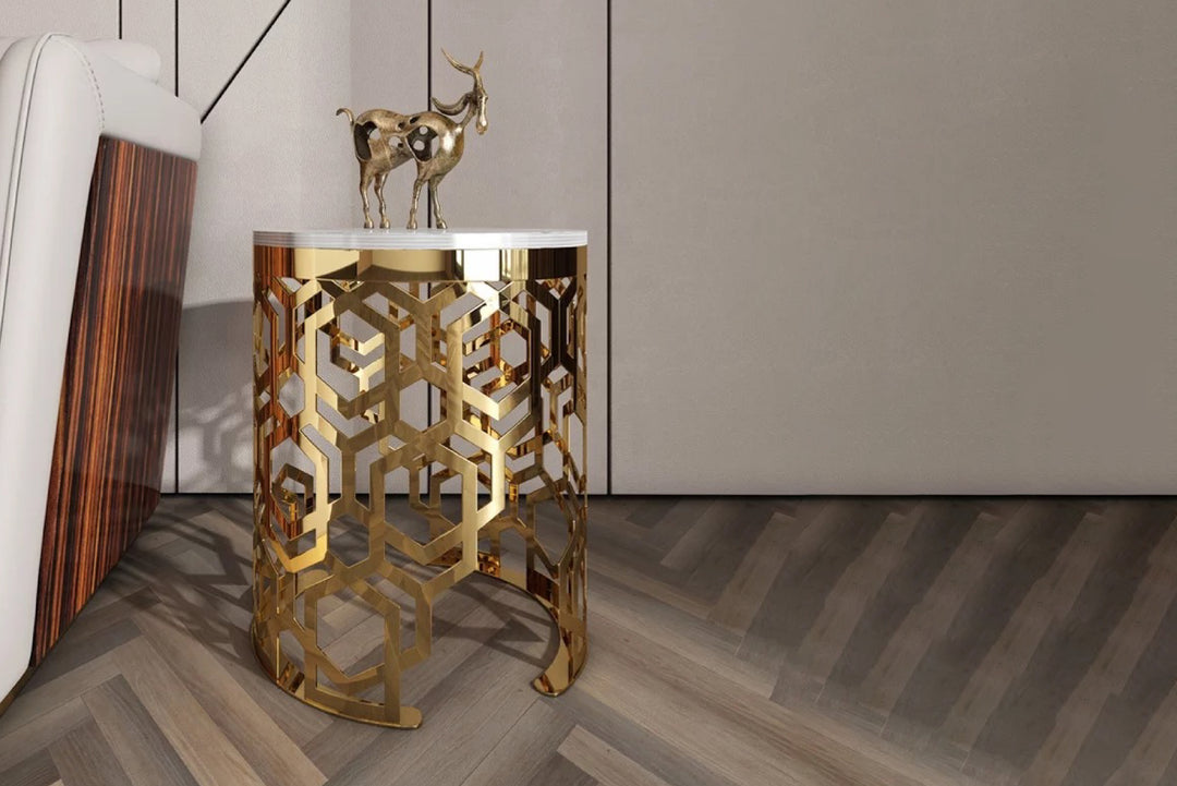 Gold decorative side table with intricate patterns in a modern interior setting.