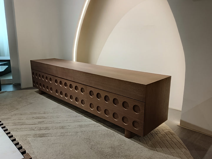 Wooden bench with circular cutouts in a minimalistic setting