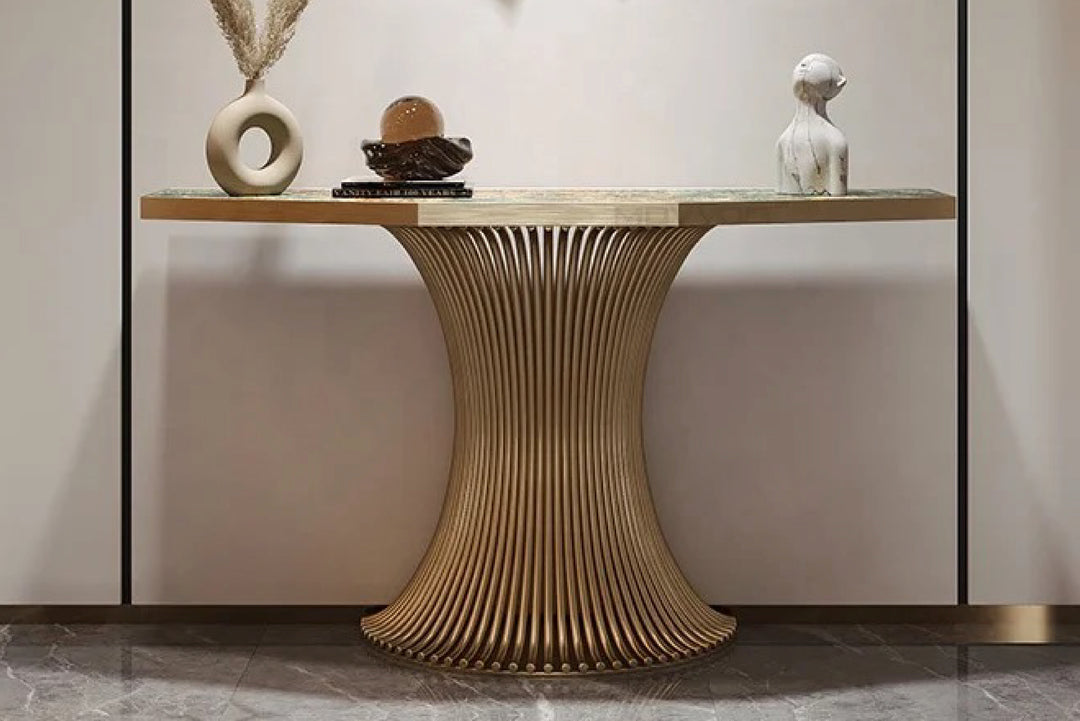 Decorative console table with a unique base design against a neutral wall.