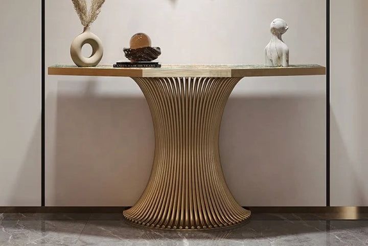 Decorative console table with a unique base design against a neutral wall.