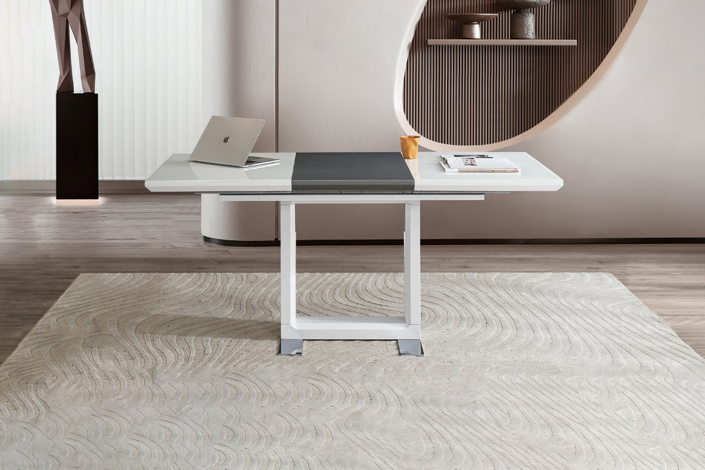 A contemporary extendable dining table with a white high-gloss engineered wood top, chrome metal legs, and black high-gloss extension, set on a patterned rug with a round mirror and decorative items in the background.