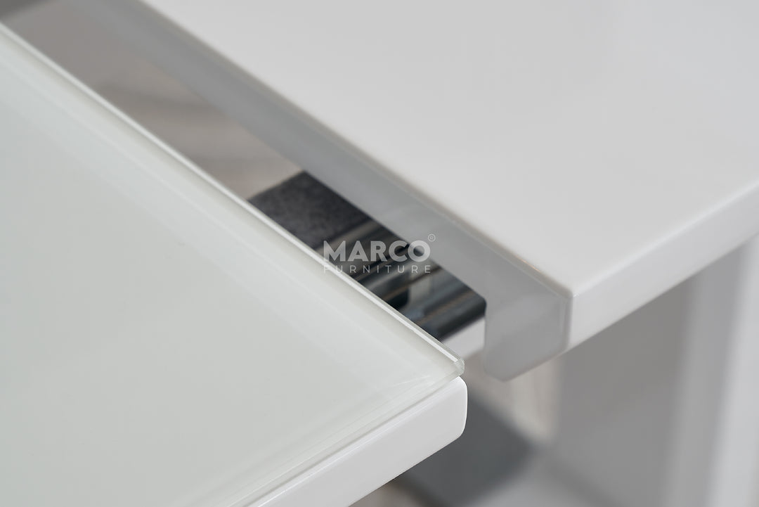 Close-up of a white drawer with a metallic handle.