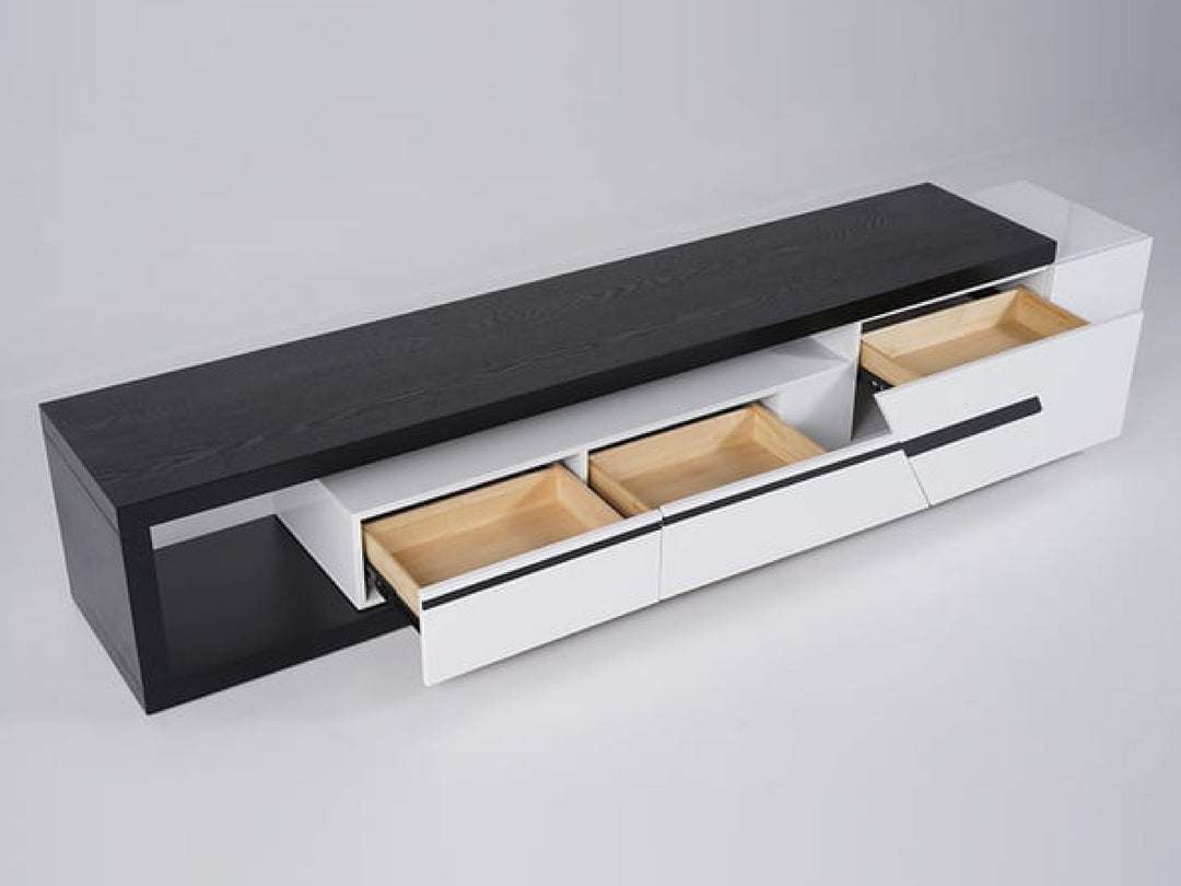 Modern entertainment console with black top and white drawers.