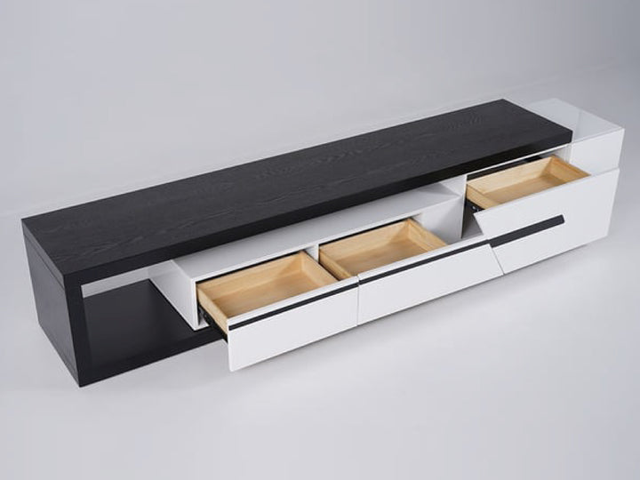 Modern entertainment console with black top and white drawers.