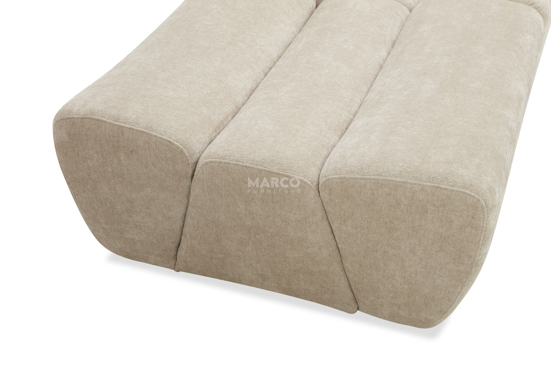 Beige fabric ottoman with 'MARCO' branding on a white background