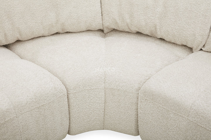 Close-up of a beige upholstered chair with a textured fabric surface.