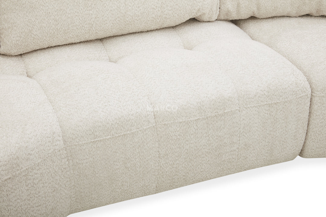Close-up of a beige upholstered chair with tufted details