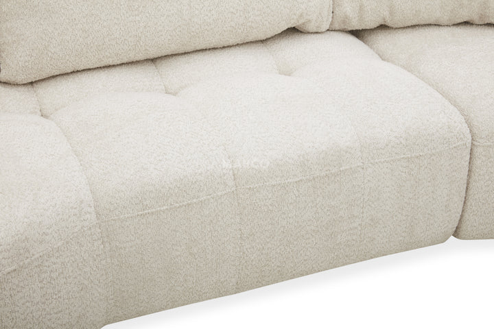 Close-up of a beige upholstered chair with tufted details