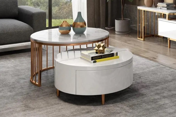 Round coffee table with marble top and wooden legs in a living room.