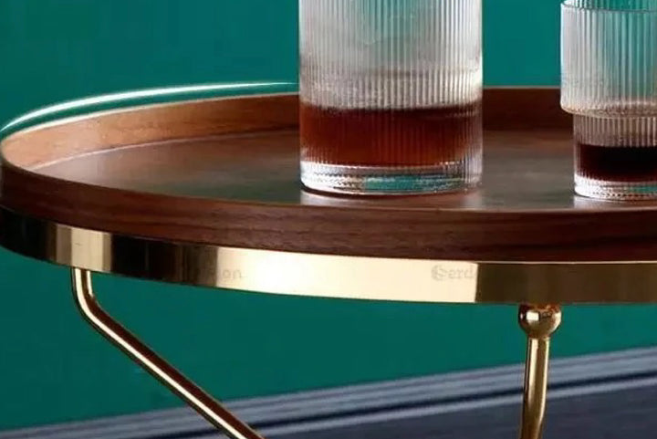 Wooden table with two glasses on a teal background