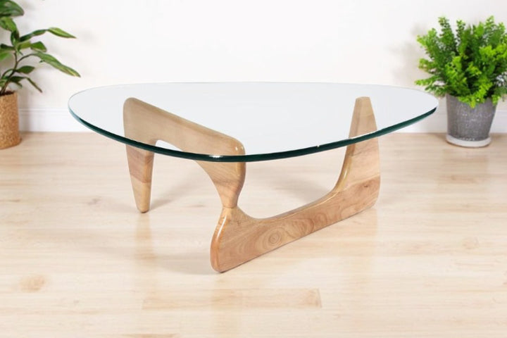 Glass coffee table with wooden legs on a light wood floor.