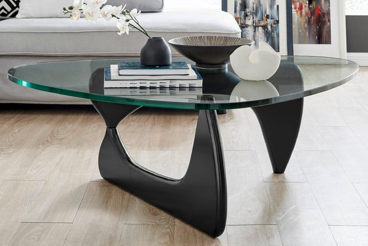 Glass coffee table with black metal base in a living room.