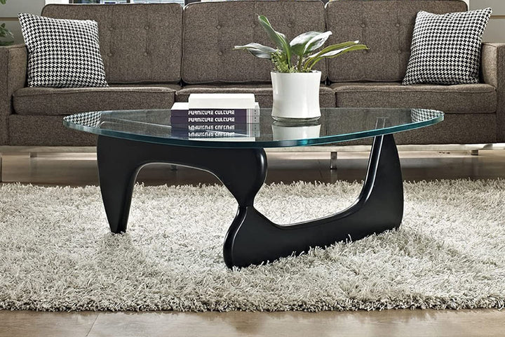 Glass coffee table with black modernist design in a living room.