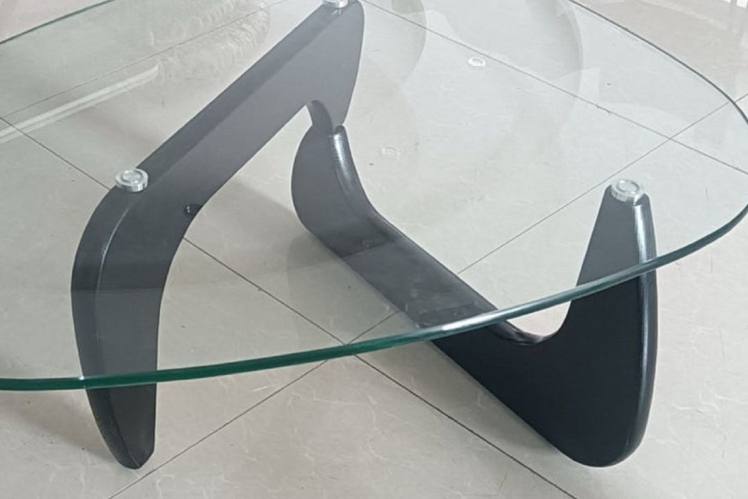 Glass coffee table with black metal frame on tiled floor