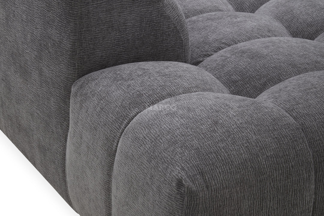 Gray tufted sofa with a close-up view of the cushions.