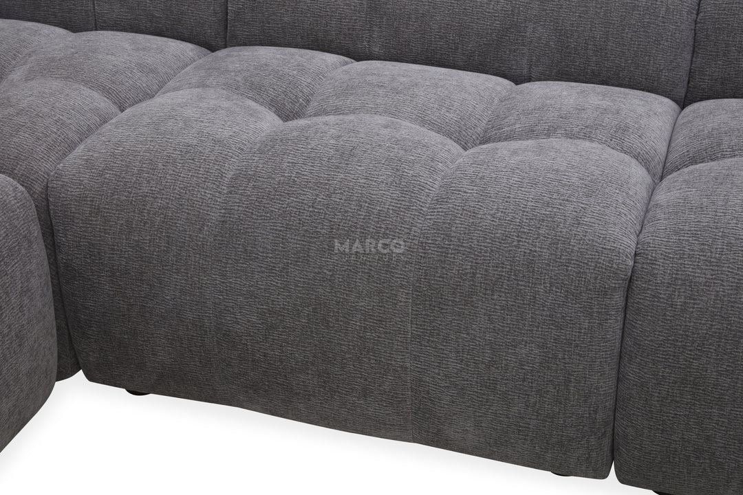 Gray tufted sofa with 'MARCO' branding on a white background