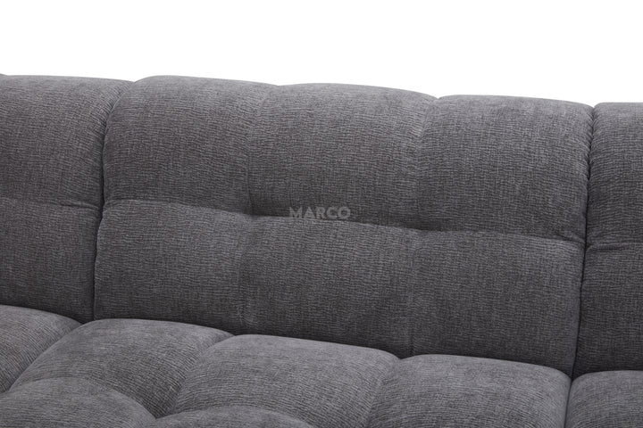 Gray tufted sofa with 'MARCO' branding on a white background