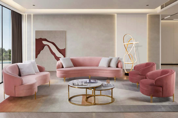 Modern living room with pink sofa and chairs, gold coffee table, and abstract art on the wall.