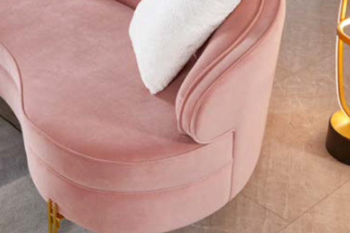 Pink velvet chair with a white cushion on a beige floor.