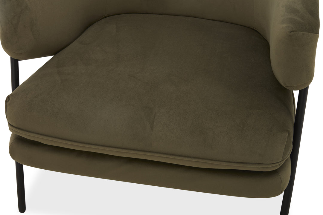 Close-up of a green upholstered chair with black metal legs on a white background