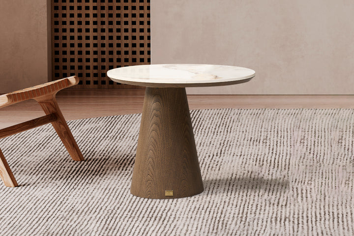 A luxury corner table with a glossy sintered stone top in Pandora Brown color, supported by a cone-shaped base with a natural grain pattern in Toffee Brown color.