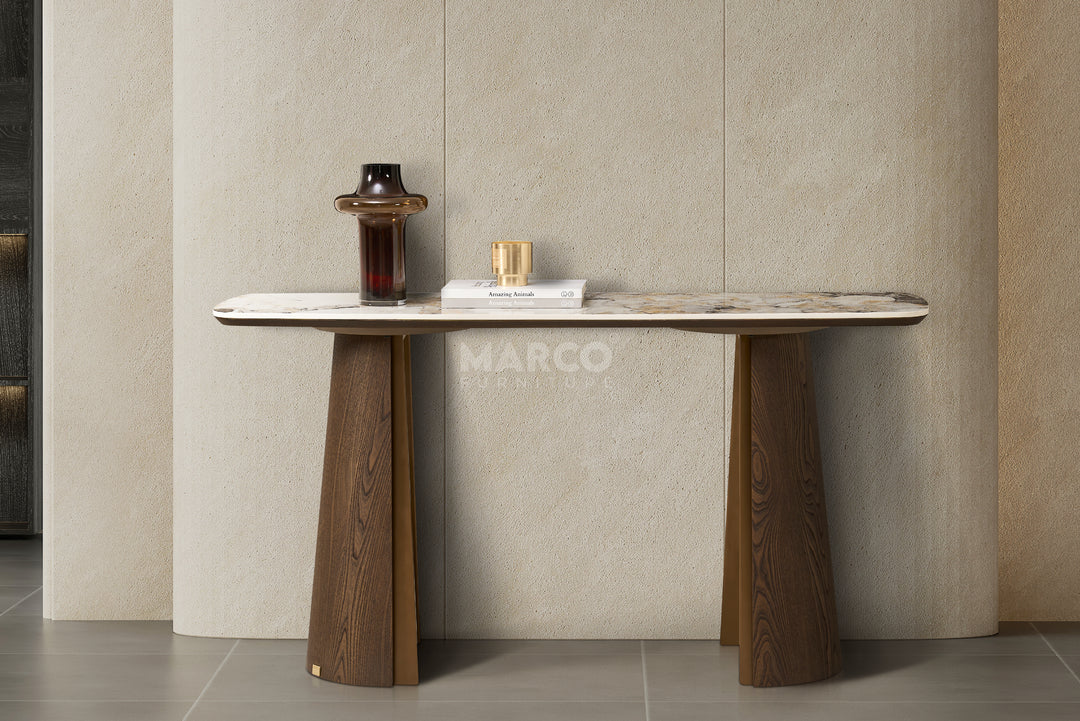 Modern console table with marble top and wooden legs against a neutral wall.